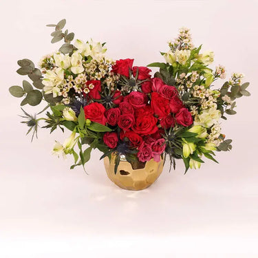 Jungle Mania in Gold, Vibrant Display, Glass Vase, Red Roses, Red Baby Roses, White Alstroemerias, Eryngium, White Wax Flowers, Cinerea Eucalyptus, Premium Golden Ceramic Glass Vase